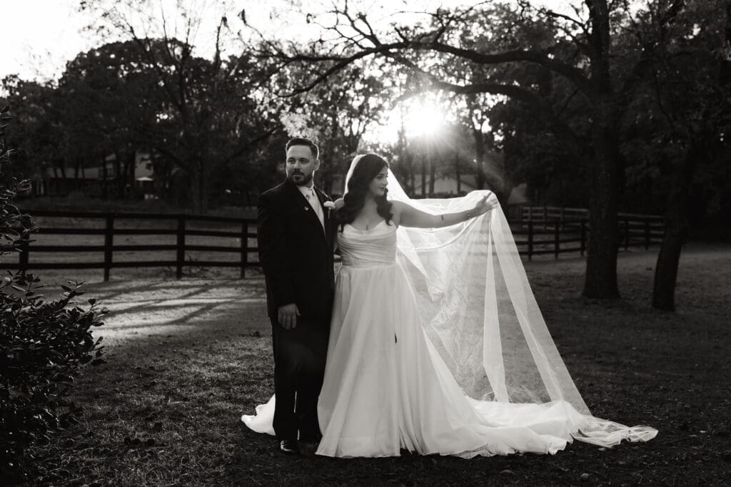 Skyler & Ryan in their wedding attire with a beautiful sunflare catching Skyler's veil.