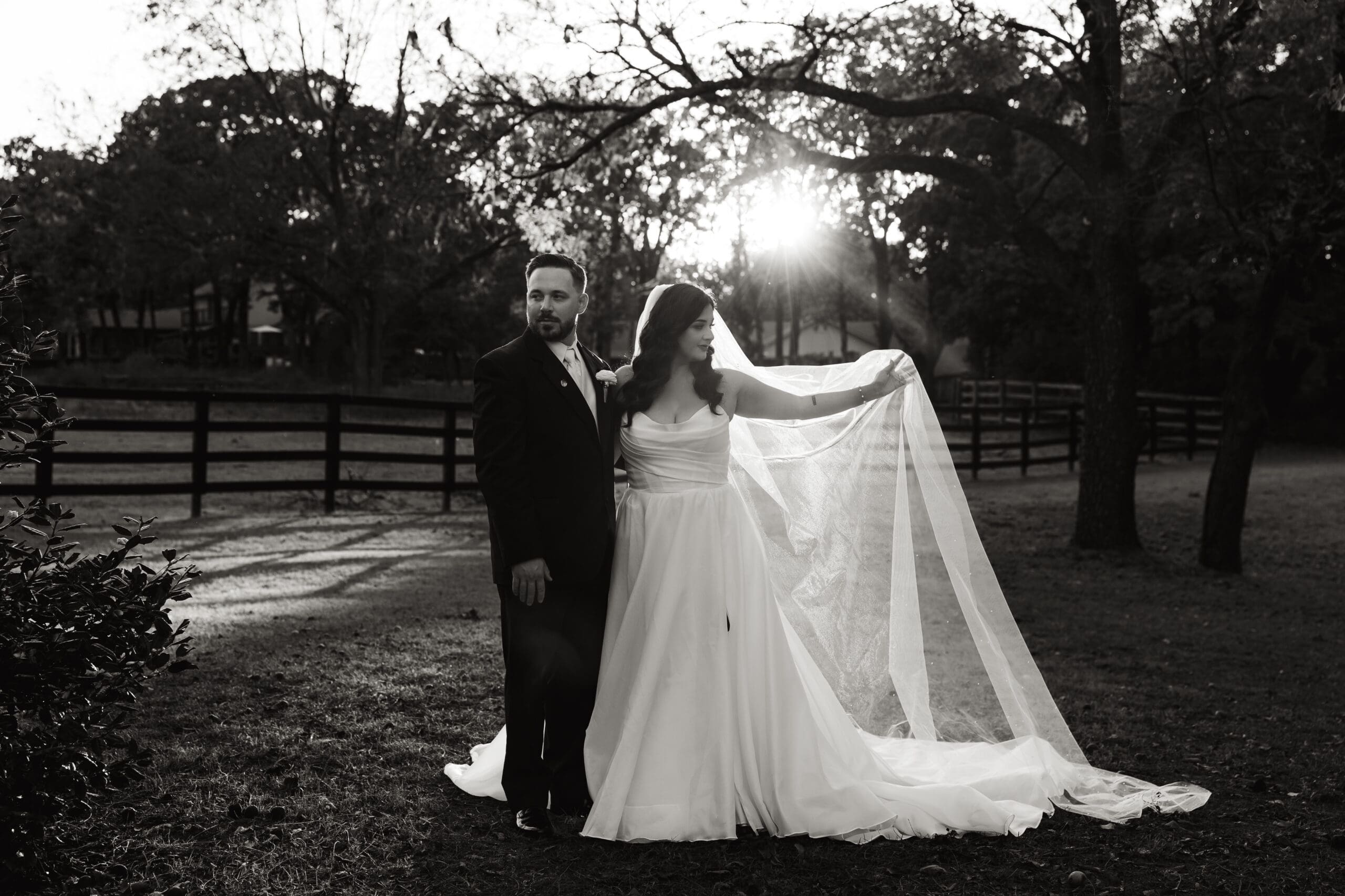 Skyler & Ryan in their wedding attire with a beautiful sunflare catching Skyler's veil.